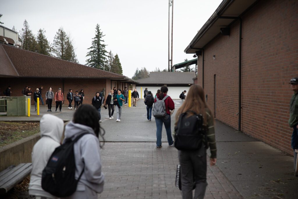 Students walk through a courtyard from the main building to the pods containing exterior classrooms. Their pathway is also regularly used for deliveries and for garbage pickup.