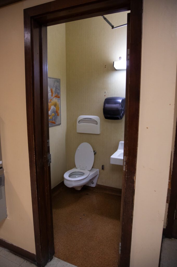 One of two single-occupancy bathrooms is housed in a closet-sized room leading directly out into the hallway.