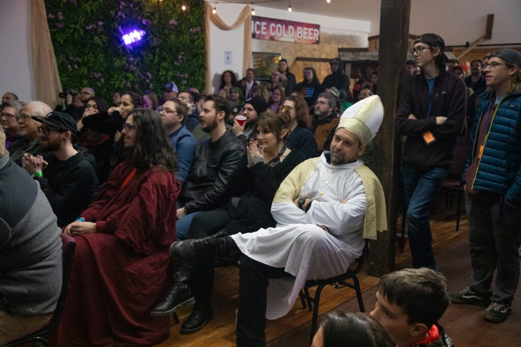 Nearly 200 people filled the hall, including one attendee dressed as the Pope.