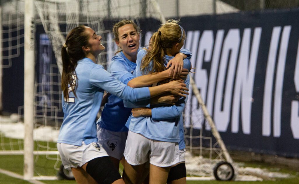 Players swarm Claire Potter in an embrace after her goal.