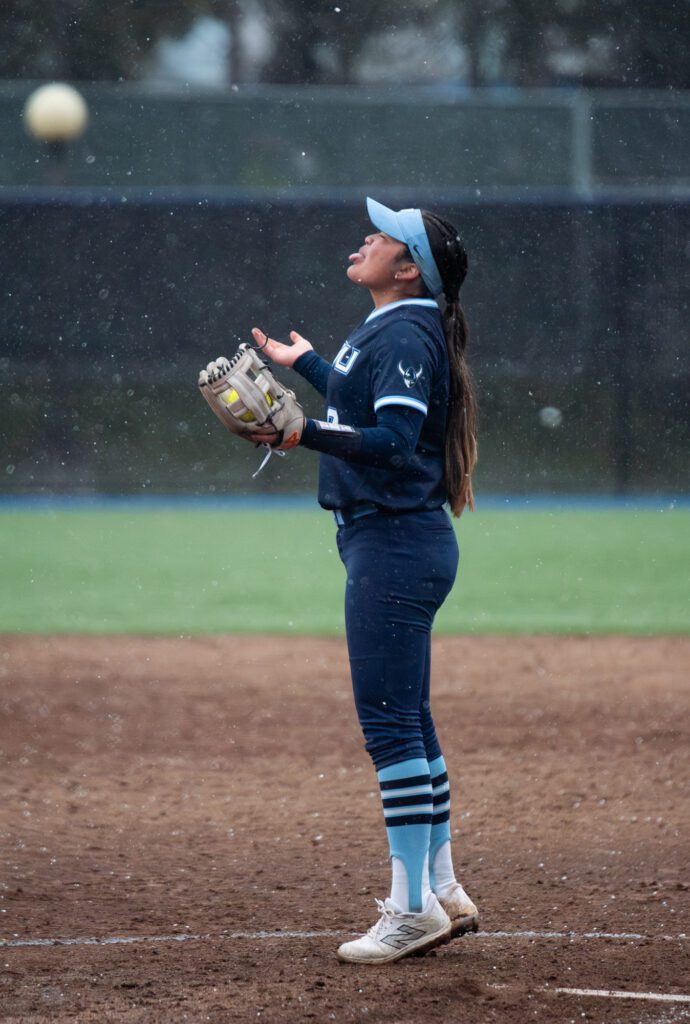 Western freshman pitcher Kaiana Kong tries to catch snow on her tongue while officials decide whether to keep the game going.