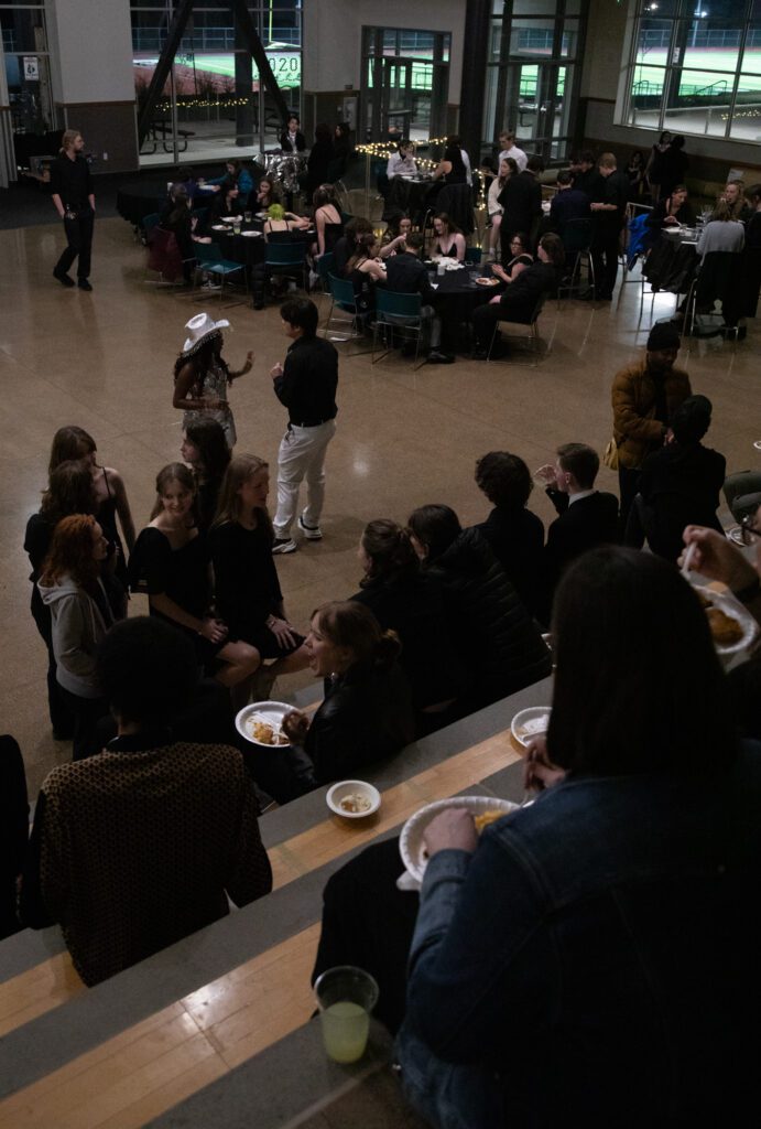 Students mingle and eat food at the start of the event.