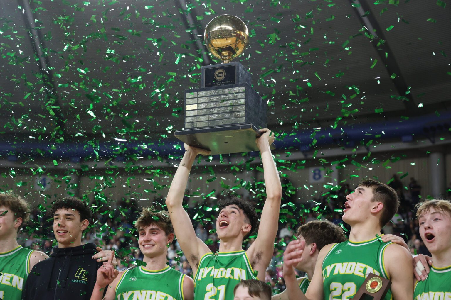 Lynden players celebrate as confetti rains down on them Saturday, March 2 after the Lions beat Grandview, 85-54, to complete the first three-peat in 2A state history at the Yakima Valley SunDome.