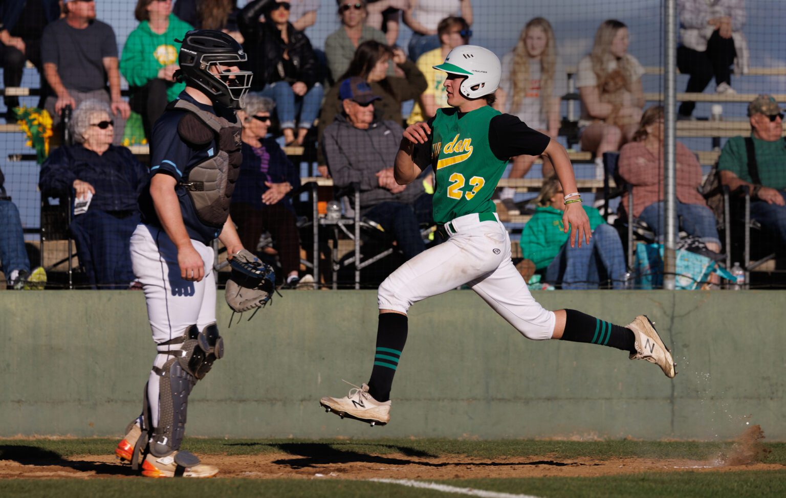 Lynden’s Brody Price leaps for the home plate as he scores a run Tuesday, March 19 during the Lions' 4-2 win over Lynden Christian at Lynden High School.
