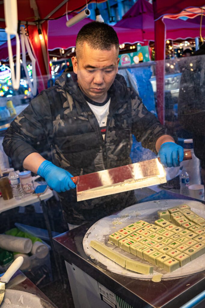 A vendor slices into fried yogurt, or "edible mahjong," at the Ho! Nice Yogurt stall.