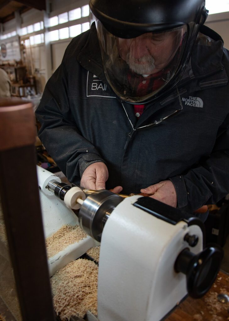 Brad Burdick, president of the Northwest Washington Woodturners, creates a spinning top out of a small piece of wood.