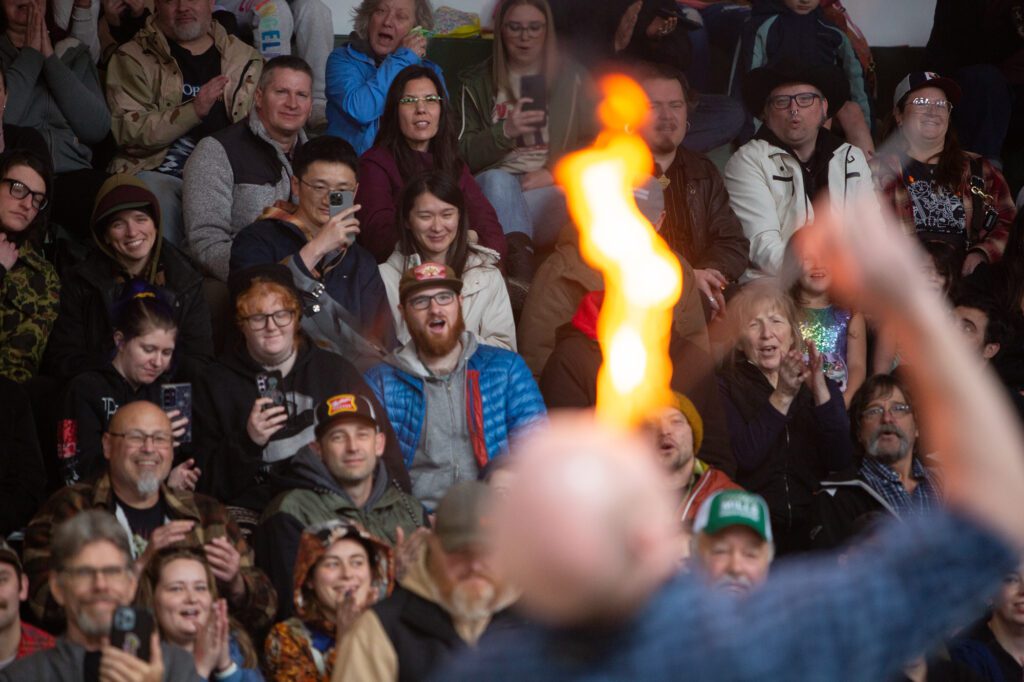 Ian Stewart swallows fire to the cheers of the crowd before juggling chainsaws.