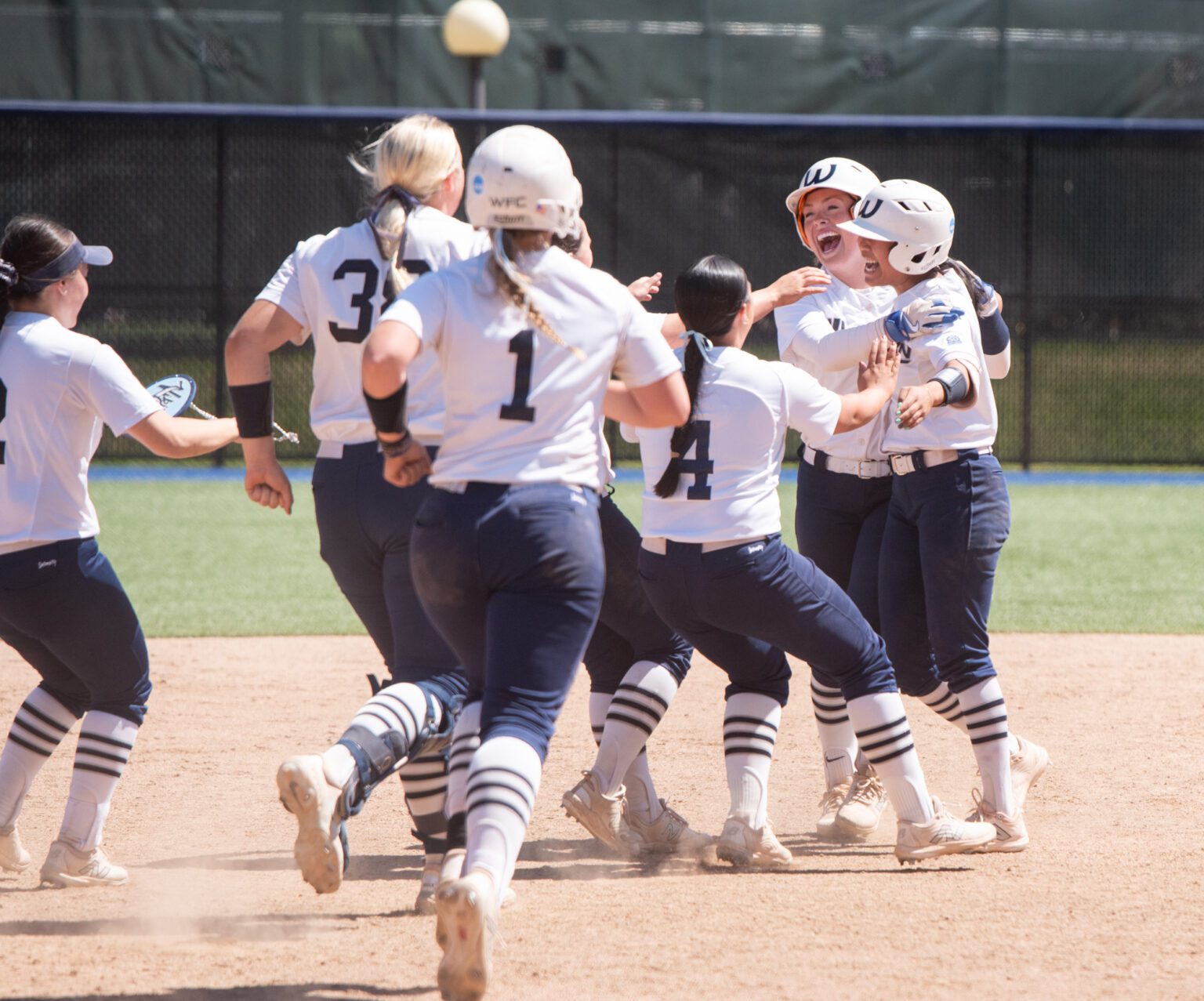 Teammates rush junior second baseman Kanilehua Pitoy, right, Thursday, May 8 after hitting a walk-off double to defeat Azusa Pacific 1-0 in the first round of the NCAA Division II West Regional Tournament.