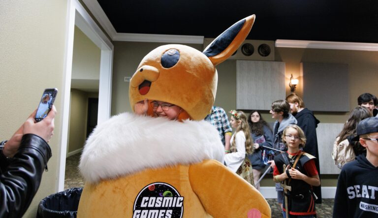 Jordan Kubichek gets her photo taken as she lifts the head of her costume, an Eevee, for the photographer.